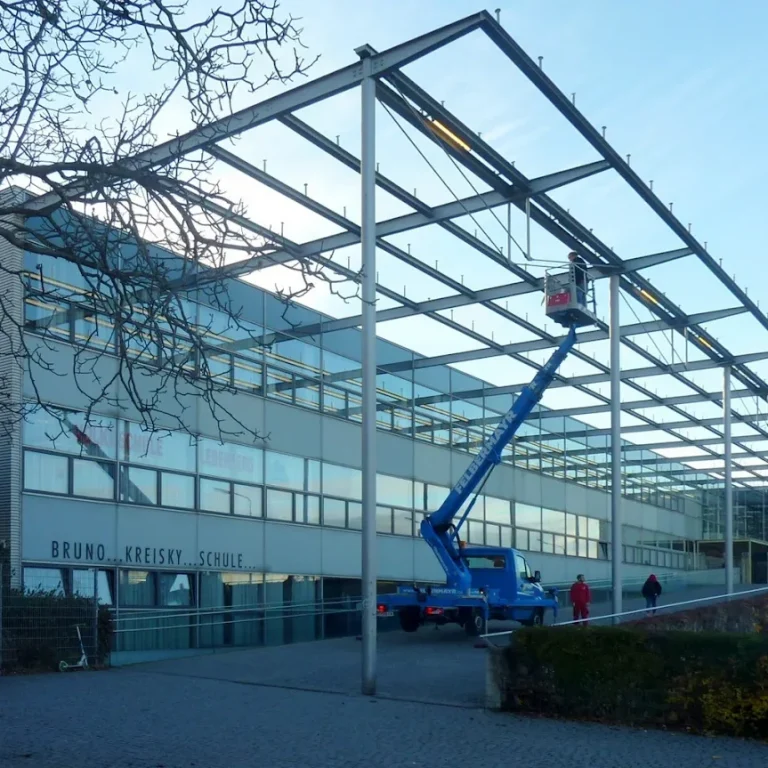 Gruppe von sieben Kindern in Fußballtrikots mit lachenden Emojis und einem Trainer auf dem Feld.