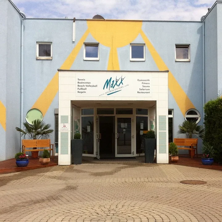 Gruppe von Kindern in Sportkleidung auf einem Fußballfeld mit einem Trainer.